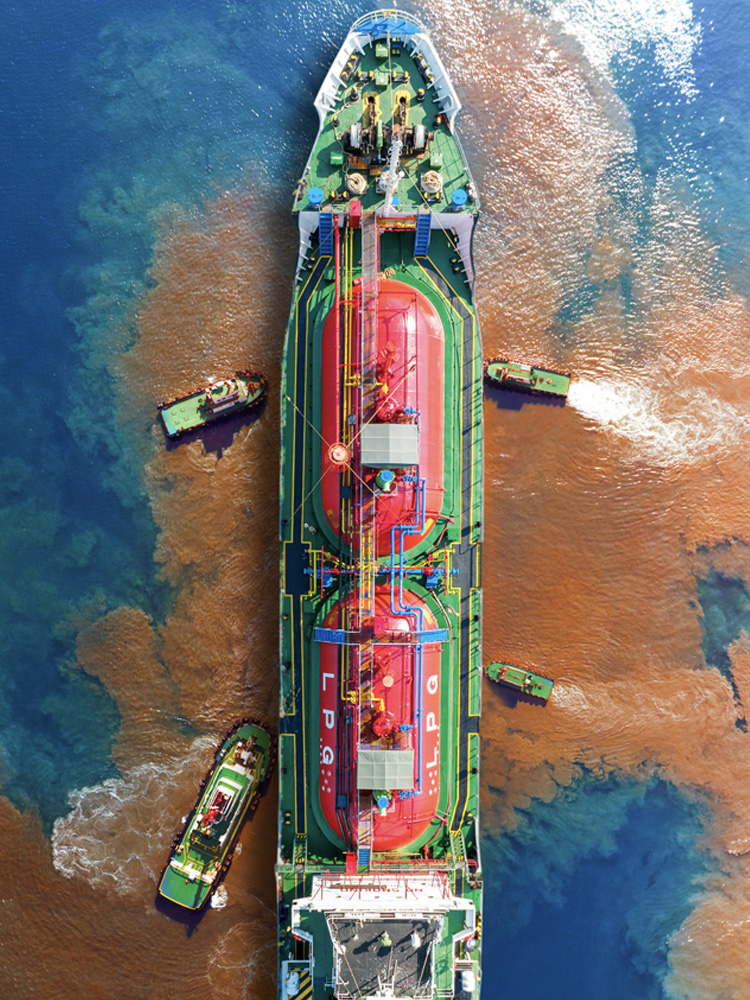 Image of a ship with oil leak in the sea and rescue ships around